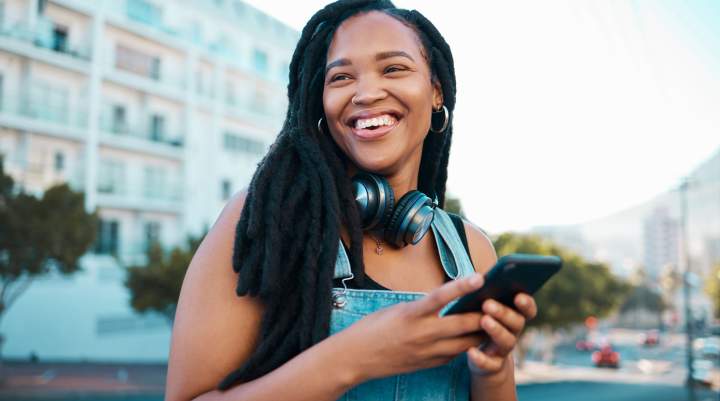 A woman happily gaming on her smartphone.